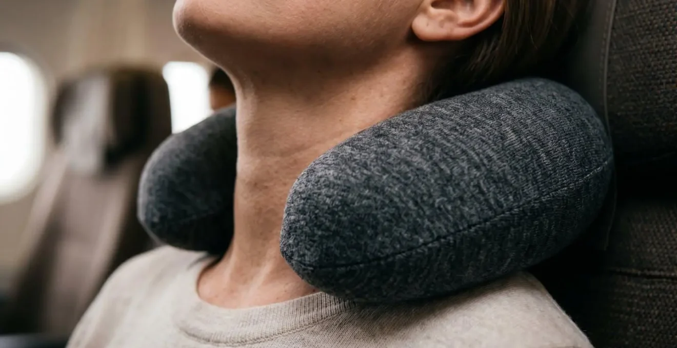 Persona che utilizza correttamente un cuscino da viaggio ergonomico in aereo