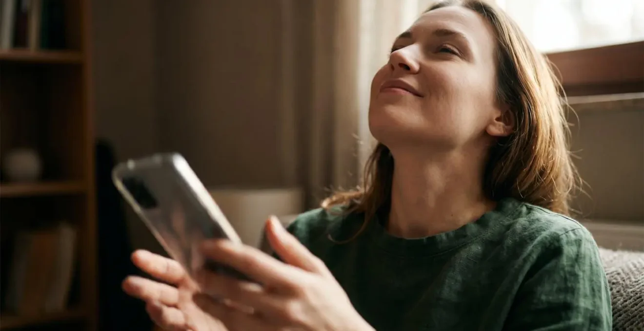 Mani che lasciano cadere uno smartphone mentre lo sguardo si alza verso l'orizzonte
