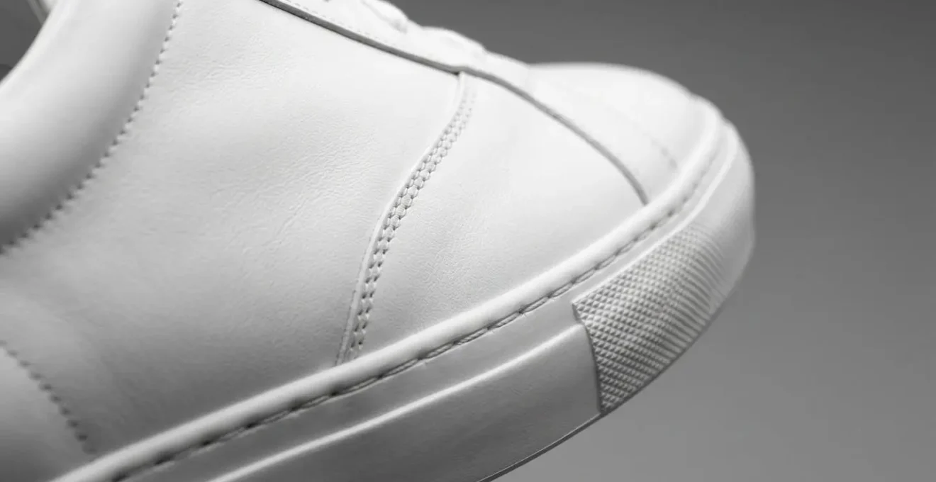 Dettaglio di sneakers bianche minimaliste in pelle di alta qualità