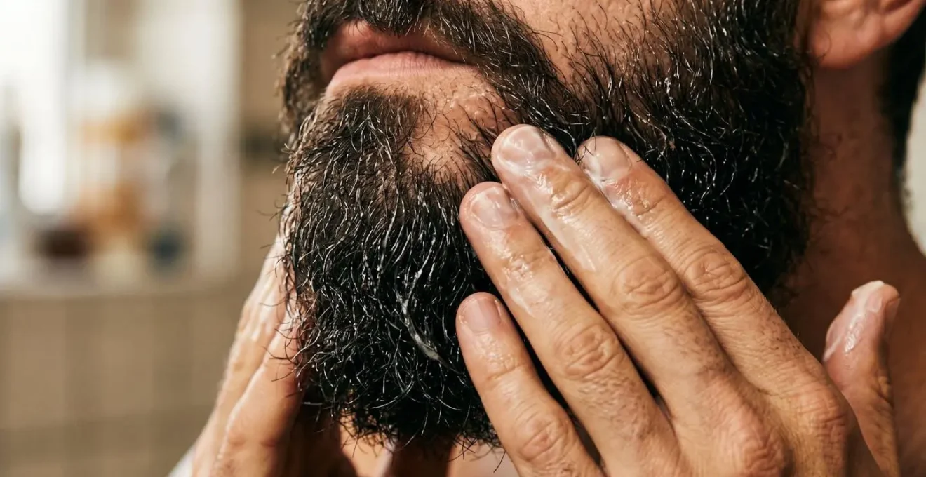 Dettaglio macro delle mani che massaggiano balsamo nella barba